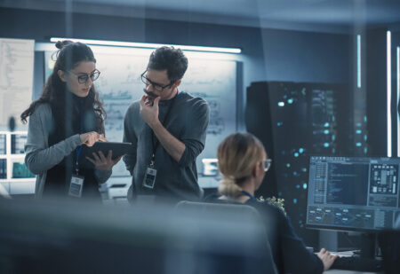 Portrait of Two Creative Young Female and Male Engineers Using T